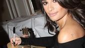 Glee star Lea Michele adds her signature to a guitar that will eventually be auctioned off to benefit Broadway Impact.
