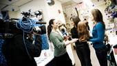 Melissa Errico&rsquo;s day begins at the Marquis Theatre as she and co-star Mara Davi (r.) give a TV crew a peek at the wigs and costumes that make White Christmas sparkle.
