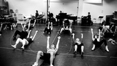 Reach for the sky! The Lysistrata Jones cast hits the floor for some intense warm-ups.